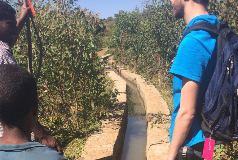 Ryan Cordier ’18 (ENG), right, views the current irrigation system in an Ethiopian village along with two local residents.