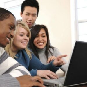 A diverse group of students gathers around a computer screen.