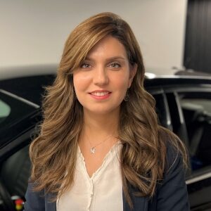 professional photo of dr. niloufar shirani in front of a black car