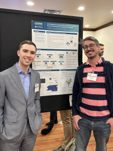 Image of Samuel Rothfarb (left) and Wilton Kort-Kamp (right) standing in front of a research poster titled “LLM Agents for Autonomous Density Functional Theory Simulations from Natural Language.” The poster displays diagrams and figures related to quantum simulations and AI agents. Both individuals are smiling, and the setting appears to be a conference poster session.